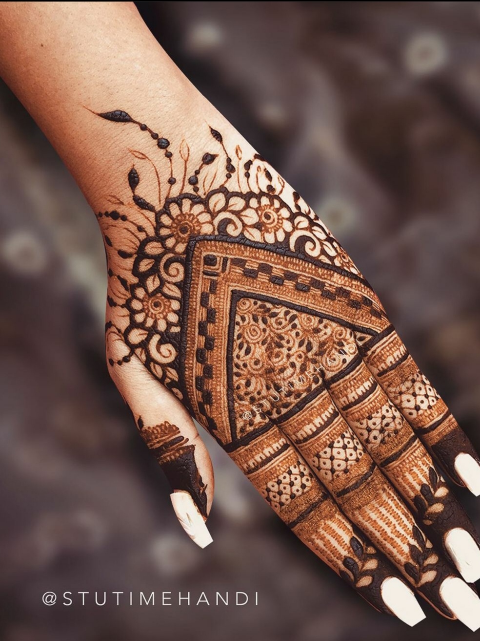 beautiful back hand mehendi design for a bride, the hand is full of henna and design is very neat