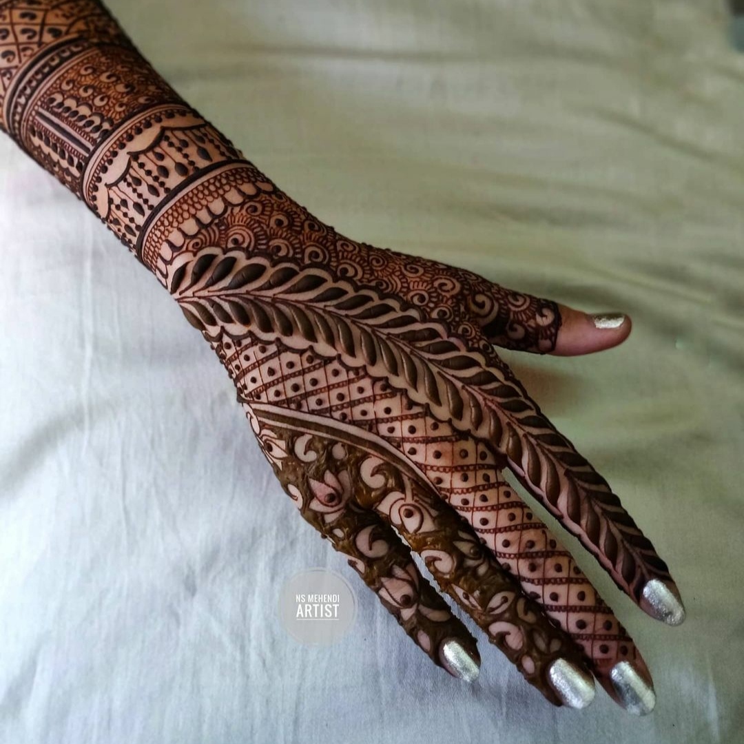 detailed back hand mehendi design with leaf like motifs