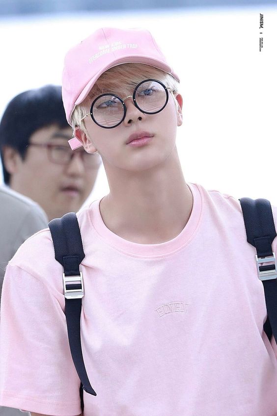Jin in pink tee and cap
