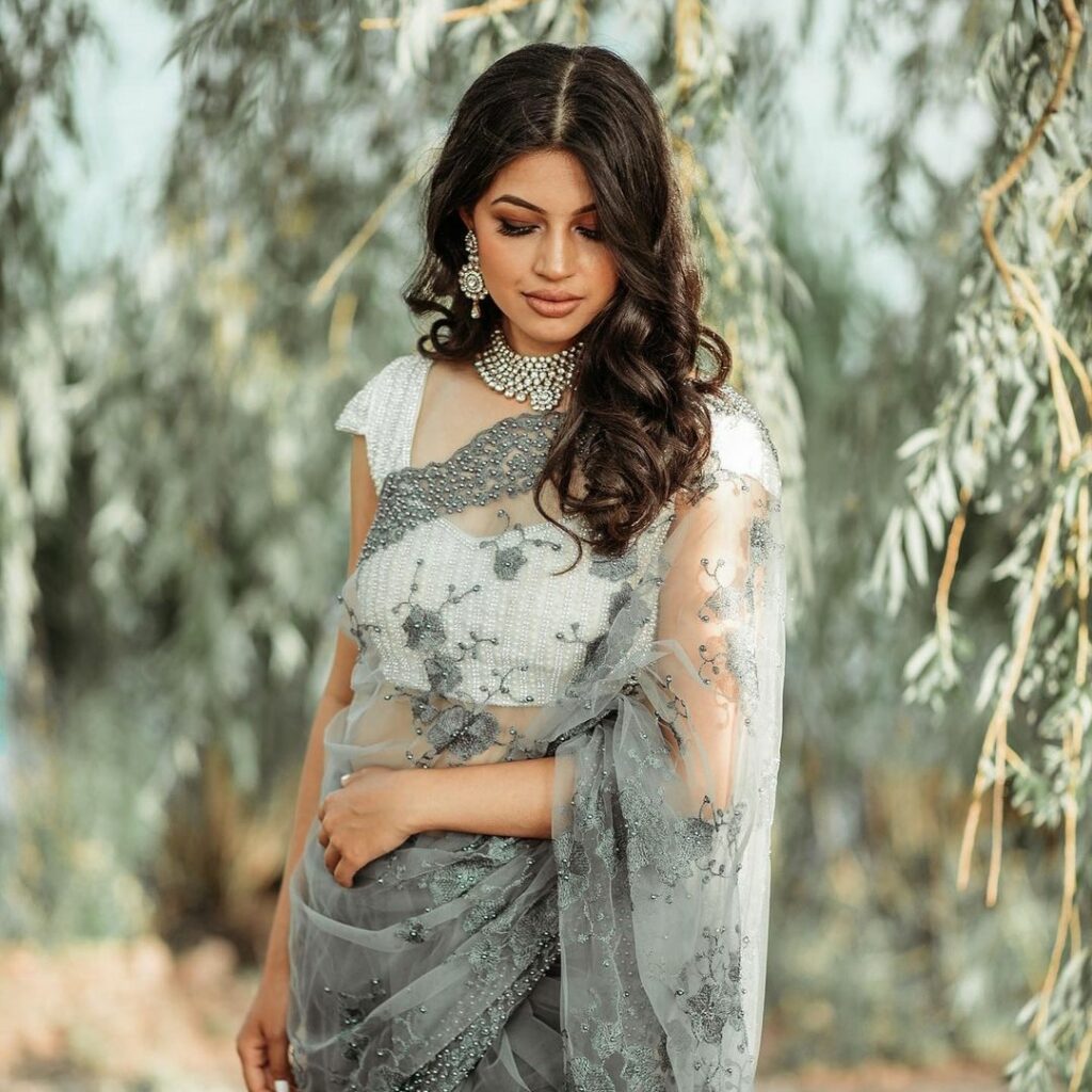 Simple side swept soft curls look with a saree