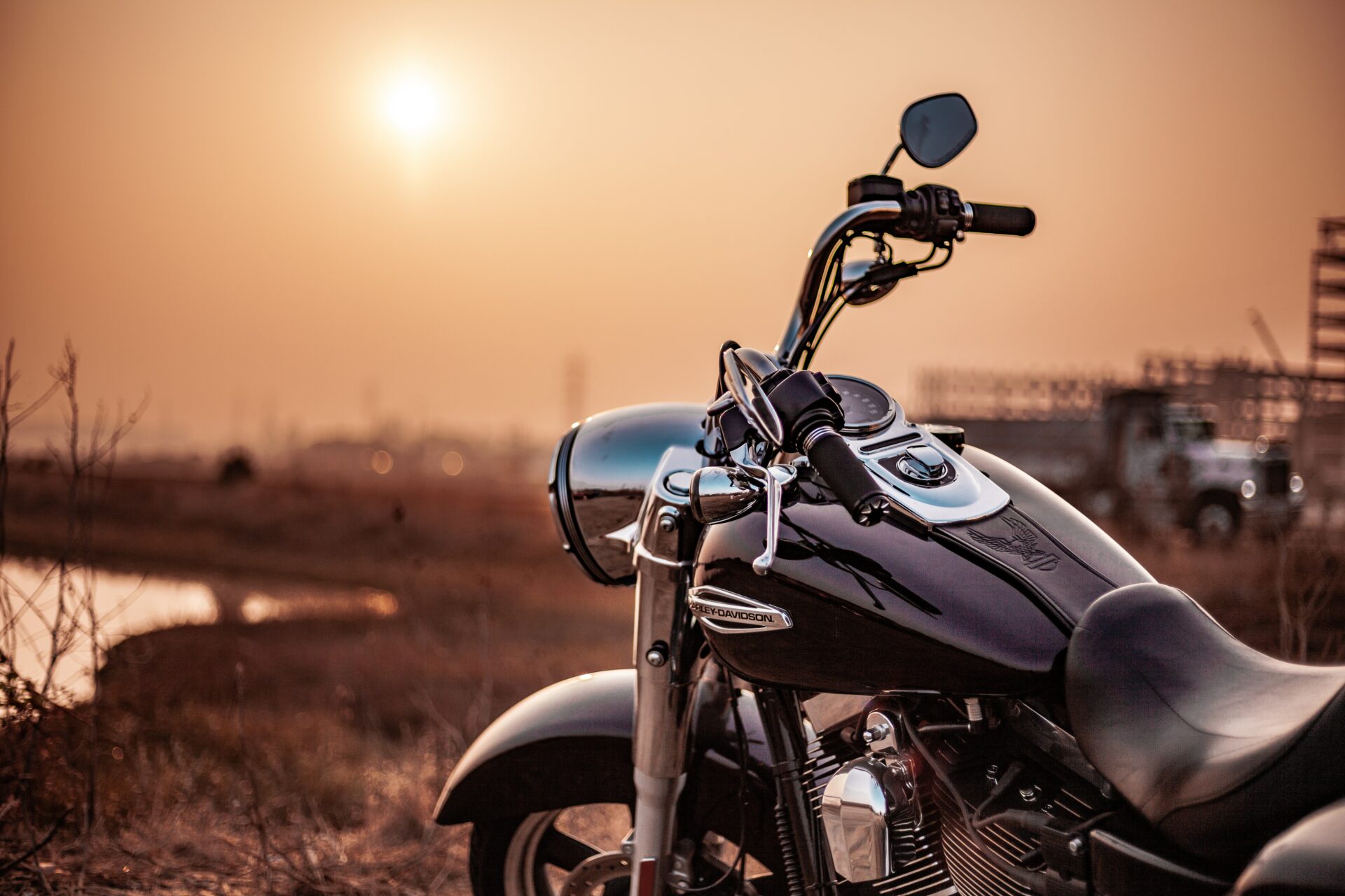  A motorcycle parked on a rural road with a sunset in the background with the factors affecting insurance monthly premium.