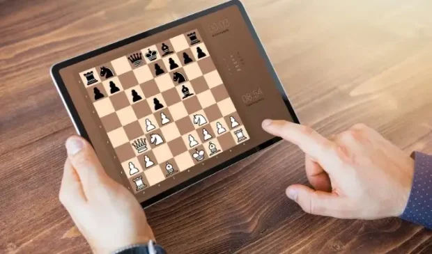 A group of friends playing online games together on their laptops and mobile phones. games to play with friends online, online games with friends, chess online with friends. Man playing Online Chess.