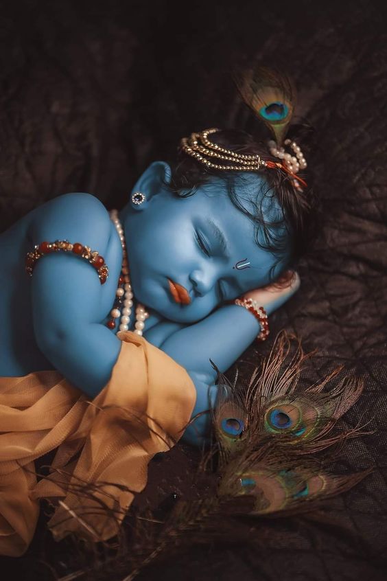 Baby Krishna sleeping with peacock feather