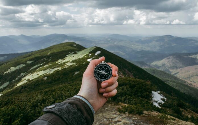 person holding silver compass, Mountains is always right destination